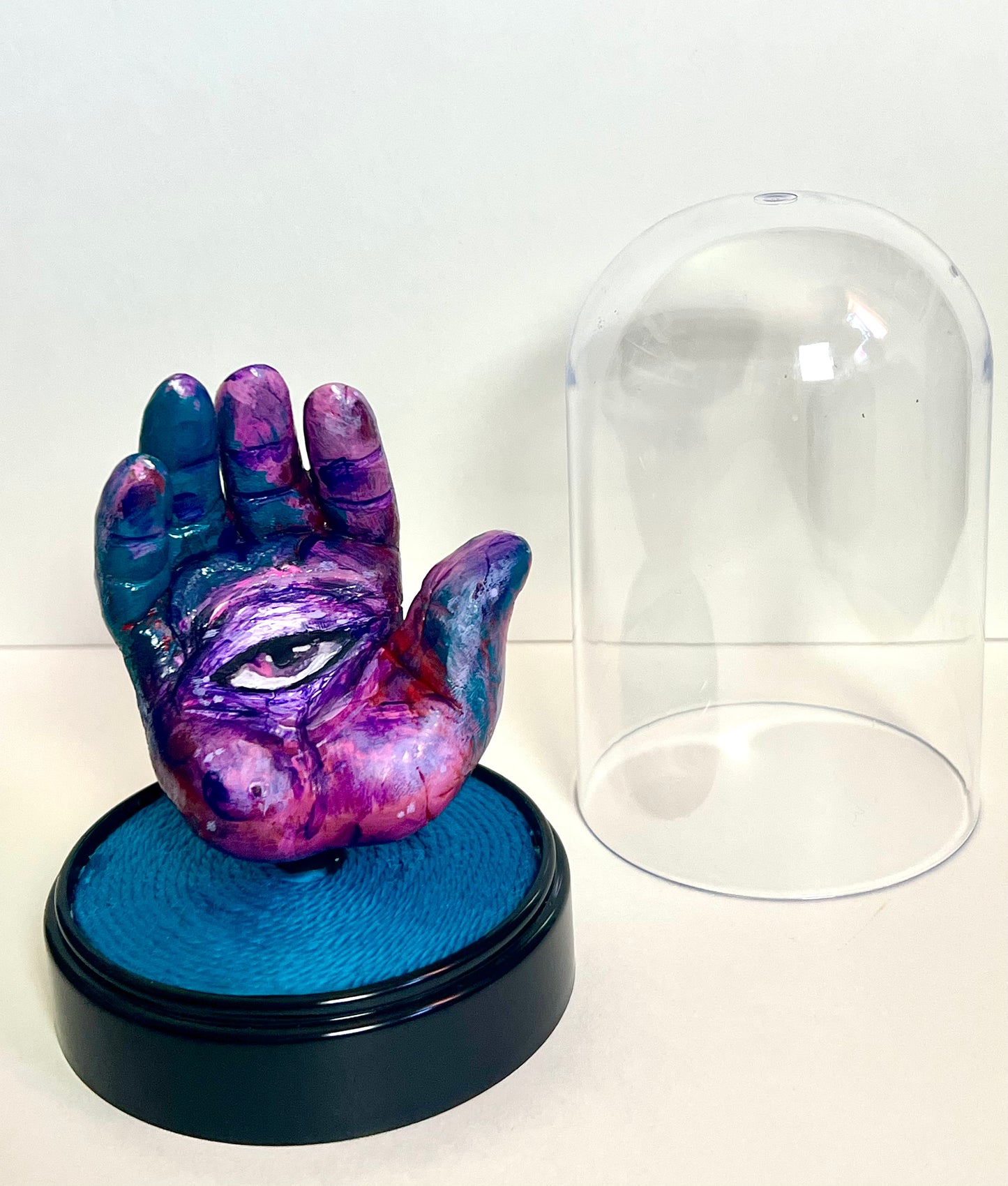 “Purple Eye” hand sculpture in cloche